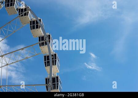 Cabine ruota panoramica in una giornata di sole con nuvole bianche Foto Stock