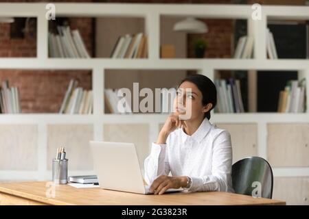 Giovane donna d'affari indiana motivata considerando i rischi del progetto. Foto Stock