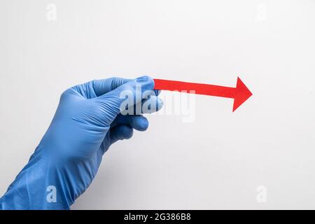 Far scorrere il guanto tenendo una freccia di carta rossa rivolta verso destra Foto Stock