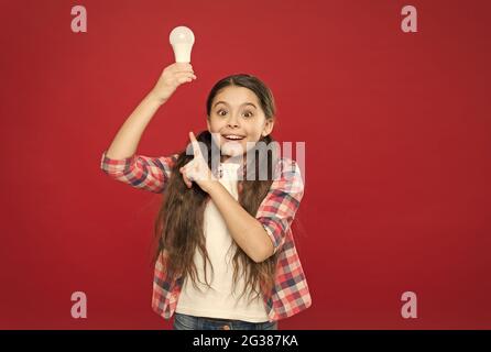 bambina stupita che punta il dito sulla lampadina con luce, ispirazione Foto Stock