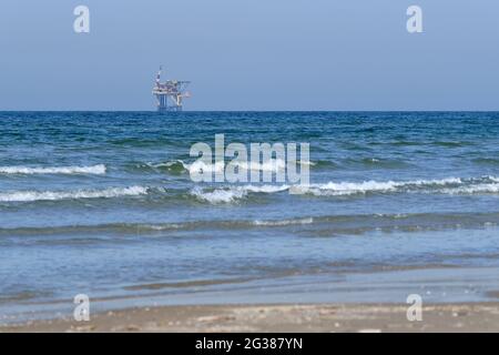 Ameland, Olanda aprile 20,2021-NAM, piattaforma offshore con spiaggia, sabbia e surf. Estrazione di gas naturale nella regione di Wadden-Mare del Nord Foto Stock