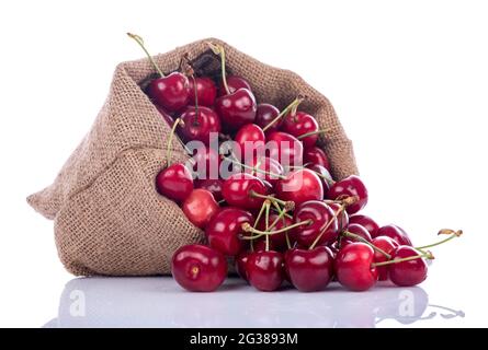 Gustose ciliegie fresche in un sacchetto di burlap, isolato su bianco Foto Stock