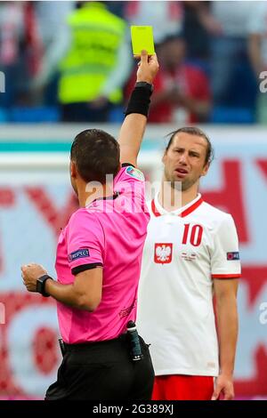 14 giugno 2021, Russia, San Pietroburgo: Calcio: Campionato europeo, Polonia - Slovacchia, turno preliminare, Gruppo e, Giornata 1 allo stadio di San Pietroburgo. L'arbitro Ovidiu Hategan mostra la polacca Grzegorz Krychowiak il cartellino giallo.importante: Solo a scopo editoriale di segnalazione delle notizie. Non utilizzato per scopi commerciali o di marketing senza previa approvazione scritta della UEFA. Le immagini devono apparire come immagini fisse e non devono emulare le riprese video con azione di corrispondenza. Le fotografie pubblicate su pubblicazioni online (via Internet o altro) devono avere un intervallo di almeno 20 secondi tra il po Foto Stock