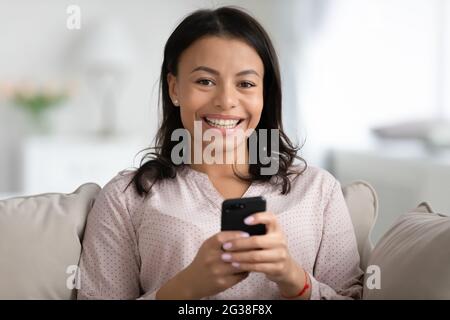 Ritratto di felice donna millenaria afroamericana che riposa sul divano Foto Stock