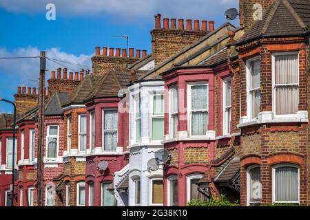 Una fila di tipiche case a schiera inglesi intorno a Kensal sorge a Londra con un palo telefonico Foto Stock