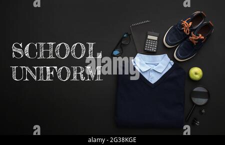 Elegante divisa da scuola con accessori su sfondo scuro Foto Stock