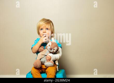 Ragazzo con mano rotta in gesso abbraccio coniglio piccolo Foto Stock