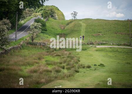 Escursioni lungo il Wall Path di Adriano, uno dei più popolari National Trails d'Inghilterra. Tra Corbridge e Chollerford si vedono raramente parti dell'antica cinta muraria romana, scomparsa sotto la strada. Chiaramente visibile è solo il fossato di fronte alla fortificazione. Foto Stock