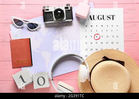 Composizione con calendario e accessori da viaggio su sfondo in legno colorato Foto Stock