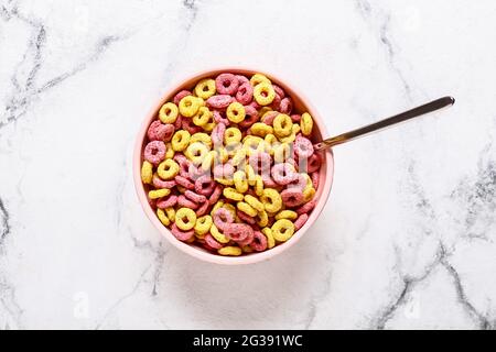 Ciotola con gustosi anelli di cereali su sfondo chiaro Foto Stock