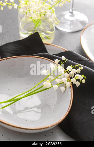 Bella tavola con fiori giglio-della-valle su sfondo grigio Foto Stock