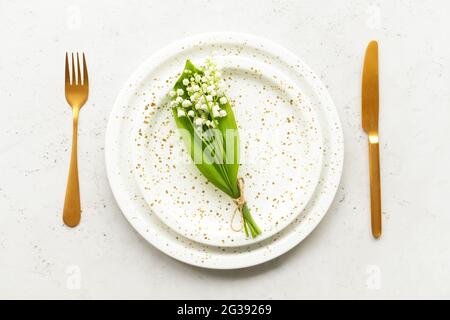 Bella tavola con fiori giglio-della-valle su sfondo chiaro Foto Stock