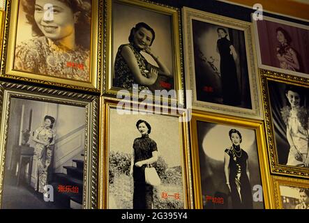 Foto di famose donne cinesi negli anni passati, tutte indossando il vestito Qipao fiancano le pareti del museo Qipao in una vecchia casa a Yantai, Cina Foto Stock