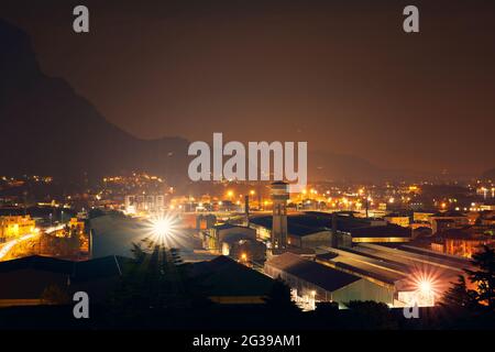Vista notturna della città con le montagne sullo sfondo. Lecco, Lombardia, Italia Foto Stock