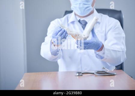 Un medico maschile con uno stetoscopio che tiene un modello anatomico Foto Stock