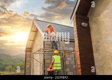 I lavoratori edili installano un nuovo tetto Foto Stock