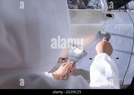 Riparazione e verniciatura auto Mechanic.worker verniciatura di un'auto Foto Stock