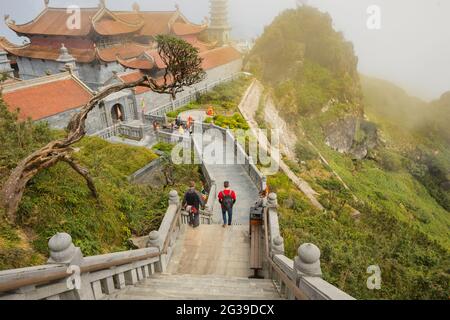 I turisti camminano verso i templi e la pagoda in cima al monte Fansipan, Sapa, nella Provice Lao Cai del Vietnam Foto Stock