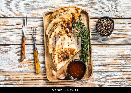 Spuntini vegetariani quesadilla con verdure e formaggio su vassoio di legno sfondo di legno bianco. Vista dall'alto Foto Stock