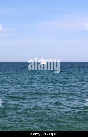 Lone barca a vela bianca in mare aperto Foto Stock