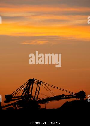 Tramonto su macchine minerarie Iron ore a Port Hedland, Australia occidentale. Foto Stock