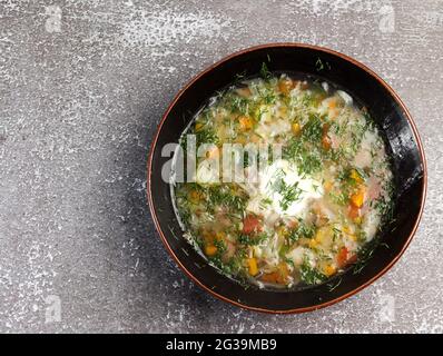 Zuppa di cavolo con erbe in una ciotola su fondo scuro. Vista dall'alto, disposizione piatta Foto Stock