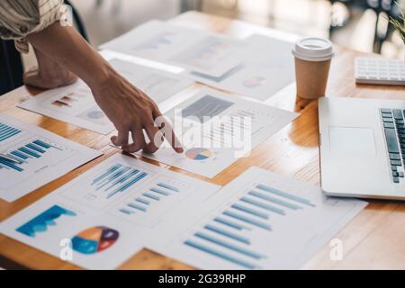 Uomo d'affari che discute le tabelle o i grafici di analisi sul tavolo da tavolo e usando il computer portatile.Chiudi l'analisi maschile e il concetto di strategia. Foto Stock