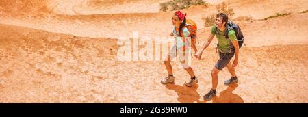 Escursionisti turisti escursionisti sul sentiero estivo trekking sul sentiero di montagna con zaini indossare scarpe da trekking. Banner panoramico della coppia attiva Foto Stock