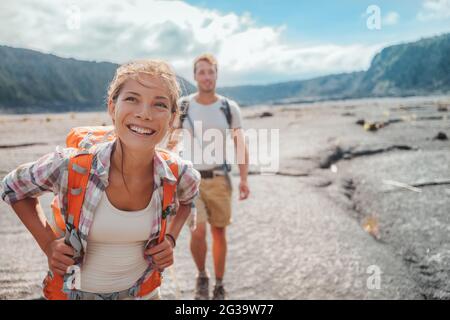 Coppia escursionistica a piedi con zaini sul sentiero del campo di lava alle Hawaii. Estate viaggio felice sorridente asiatico ragazza e uomo escursionisti avventura all'aperto su Big Foto Stock