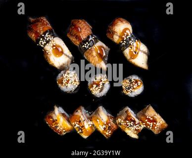 panini al forno e sushi su sfondo nero vista dall'alto. Foto Stock
