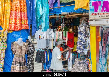 Il trader indiano spolverò i vestiti sul suo colorato stallone di abbigliamento, Palolem, Goa, India Foto Stock