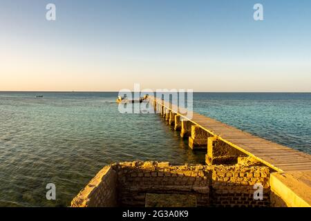 Vecchio molo in legno (molo) del faro di Sanganeb Reef vicino a Port Sudan, sul Mar Rosso, nel Parco Nazionale di Sanganeb, con orizzonte infinito vista mare duri Foto Stock