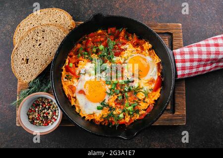 Shakshuka in una padella. Piatto tradizionale mediorientale. Uova fritte con pomodori sause. Vista dall'alto Foto Stock