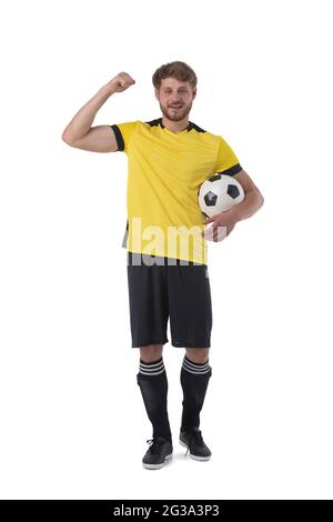 Il giocatore di calcio sta tenendo la palla che mostra il muscolo che tiene pugno celebrando la vittoria isolata su sfondo bianco Foto Stock