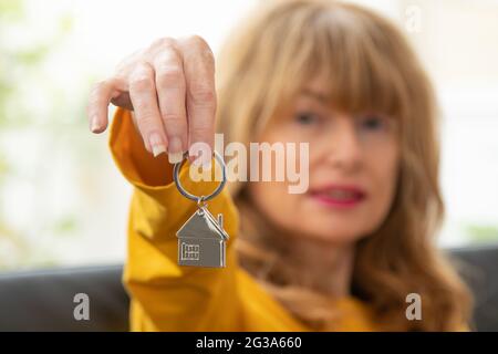 donna con la chiave della casa in mano, casa d'acquisto Foto Stock