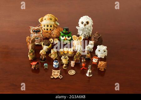 Figurine giocattolo di gufi di diverse forme e dimensioni su un tavolo di legno Foto Stock