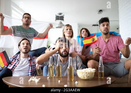 Amici sconvolti e frustrati che guardano la partita di calcio a casa Foto Stock