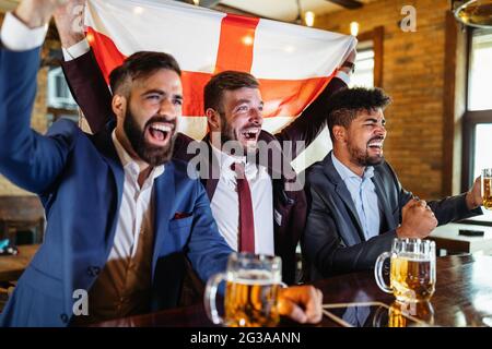 Persone, tempo libero, amicizia, concetto di sport. Amici felici bere birra, guardare la partita di sport al pub Foto Stock