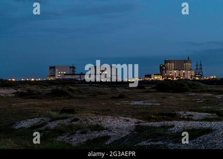 La centrale nucleare di Dungeness A & B è vista dall'altra parte dello shingle al crepuscolo, Dungeness, Romney Marsh, Kent, Engand, REGNO UNITO. Foto Stock