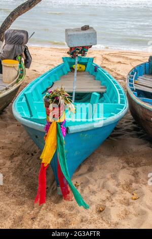 Le colorate barche da pesca sono lasciate sulla spiaggia in serata Foto Stock