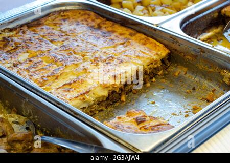 Il pasticcio nella padella a cottura lenta, posto in un contenitore contenente acqua calda Foto Stock