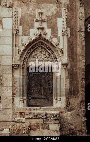 Closeup verticale di un muro di pietra con una porta ad arco sul Castello di Corvin in Romania Foto Stock