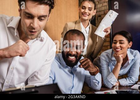 i colleghi aziendali multietnici hanno mostrato un gesto di vittoria in un primo piano sfocato Foto Stock