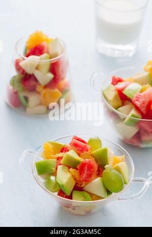 Pezzi di frutta tropicale in un bicchiere. Fette di arancia, Apple, fette di cocomero in recipiente di vetro. Agrumi Foto Stock