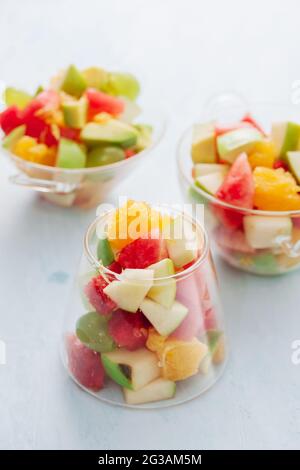 Pezzi di frutta tropicale in un bicchiere. Fette di arancia, Apple, fette di cocomero in recipiente di vetro. Agrumi Foto Stock