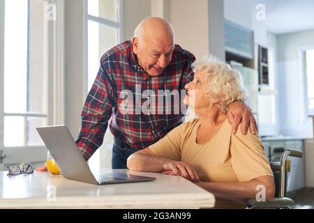 Felice coppia anziana in pensione che usa un computer portatile a casa o residenza senior Foto Stock