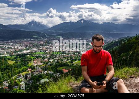 Controllare le e-mail con Innsbruck in background Foto Stock