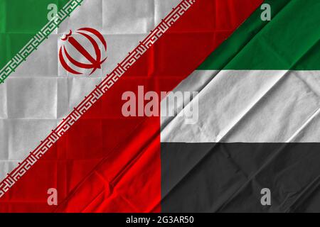 Concetto del rapporto tra Iran ed Emirati Arabi Uniti con due bandiere l'una sull'altra Foto Stock