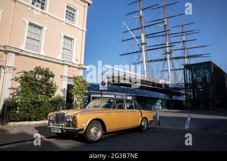 Un'automobile di Rolls Royce siede fuori di una casa a schiera su King William Walk con il Sark di Cutty sullo sfondo, Greenwich, Londra sudorientale, Inghilterra Foto Stock