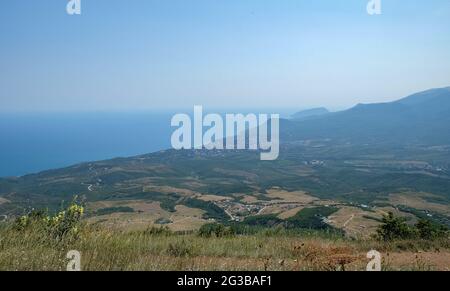 Vista di Alushta e della montagna Ayu-Dag dalla cima della catena montuosa Demerdzhi in Crimea. Foto Stock